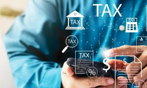 Individual preparing tax return with financial documents and calculator